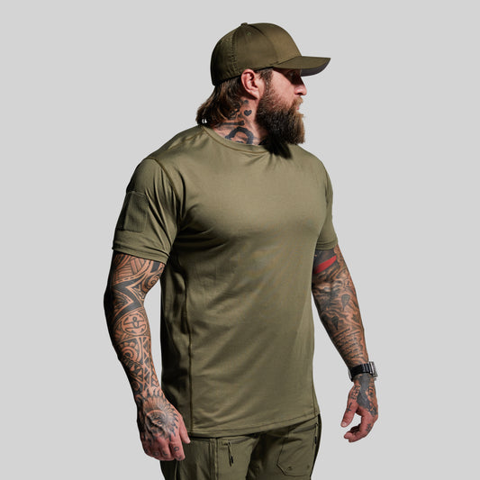 Man wearing an olive green t-shirt and cap on a gray background