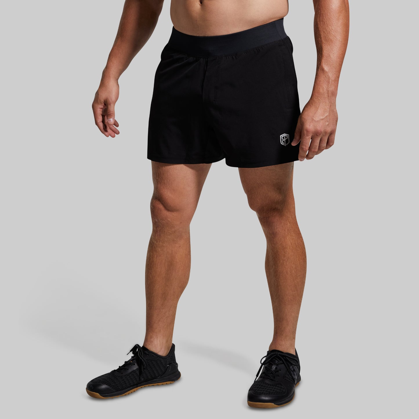 Person wearing black shorts on a gray background