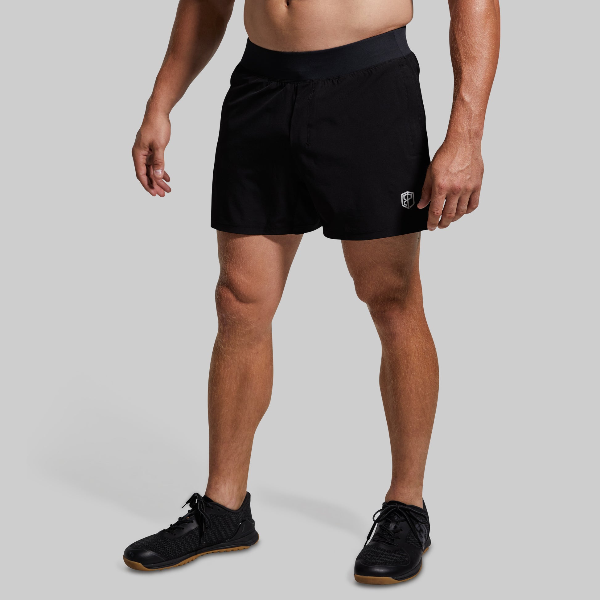 Person wearing black shorts on a gray background
