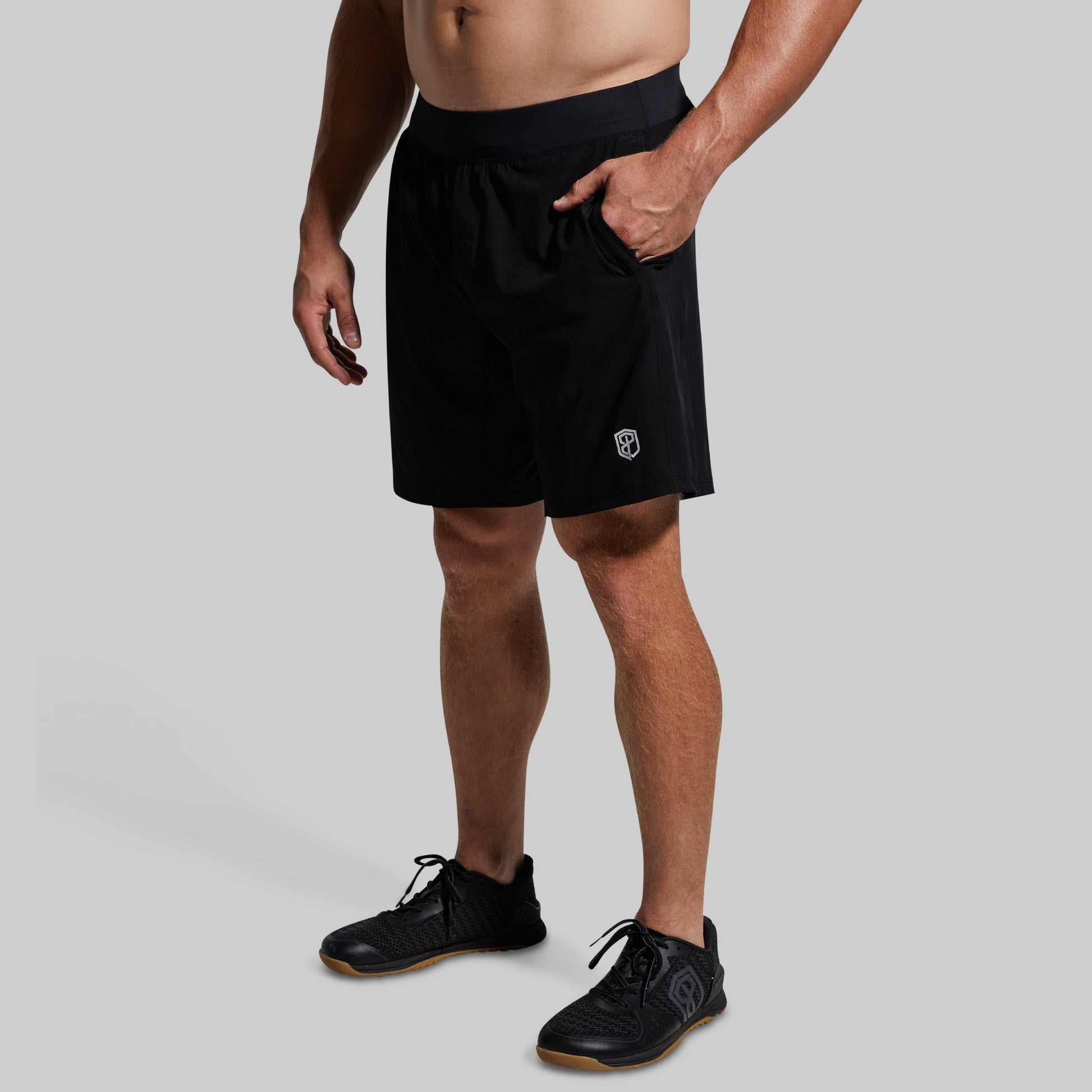 Person wearing black athletic shorts on a gray background