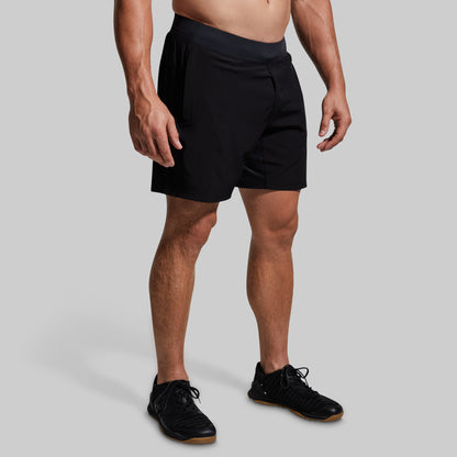 Person wearing black athletic shorts on a gray background