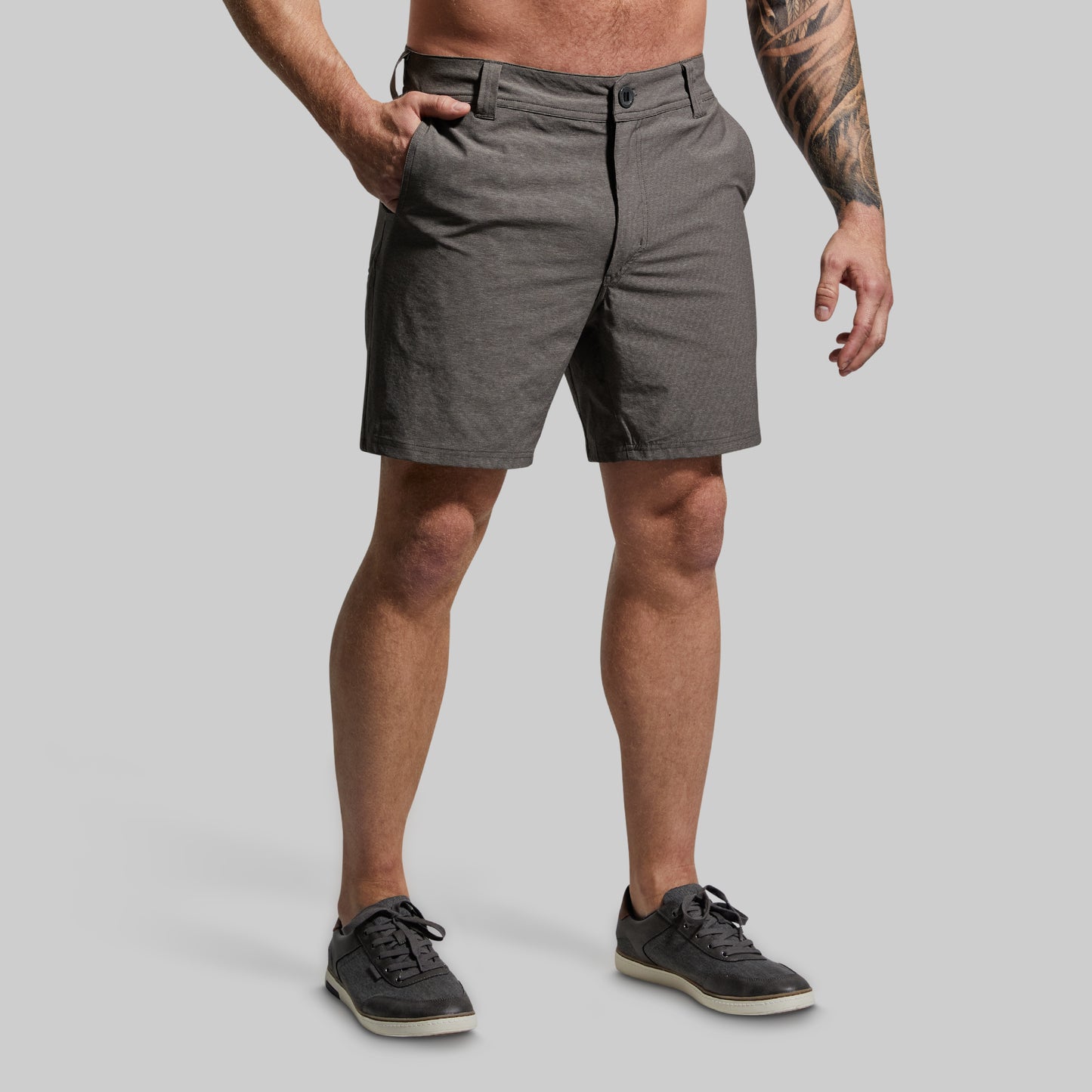Person wearing gray shorts on a plain background