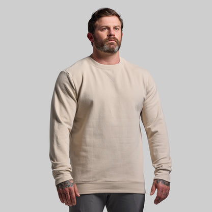 Man wearing a beige sweatshirt against a plain background