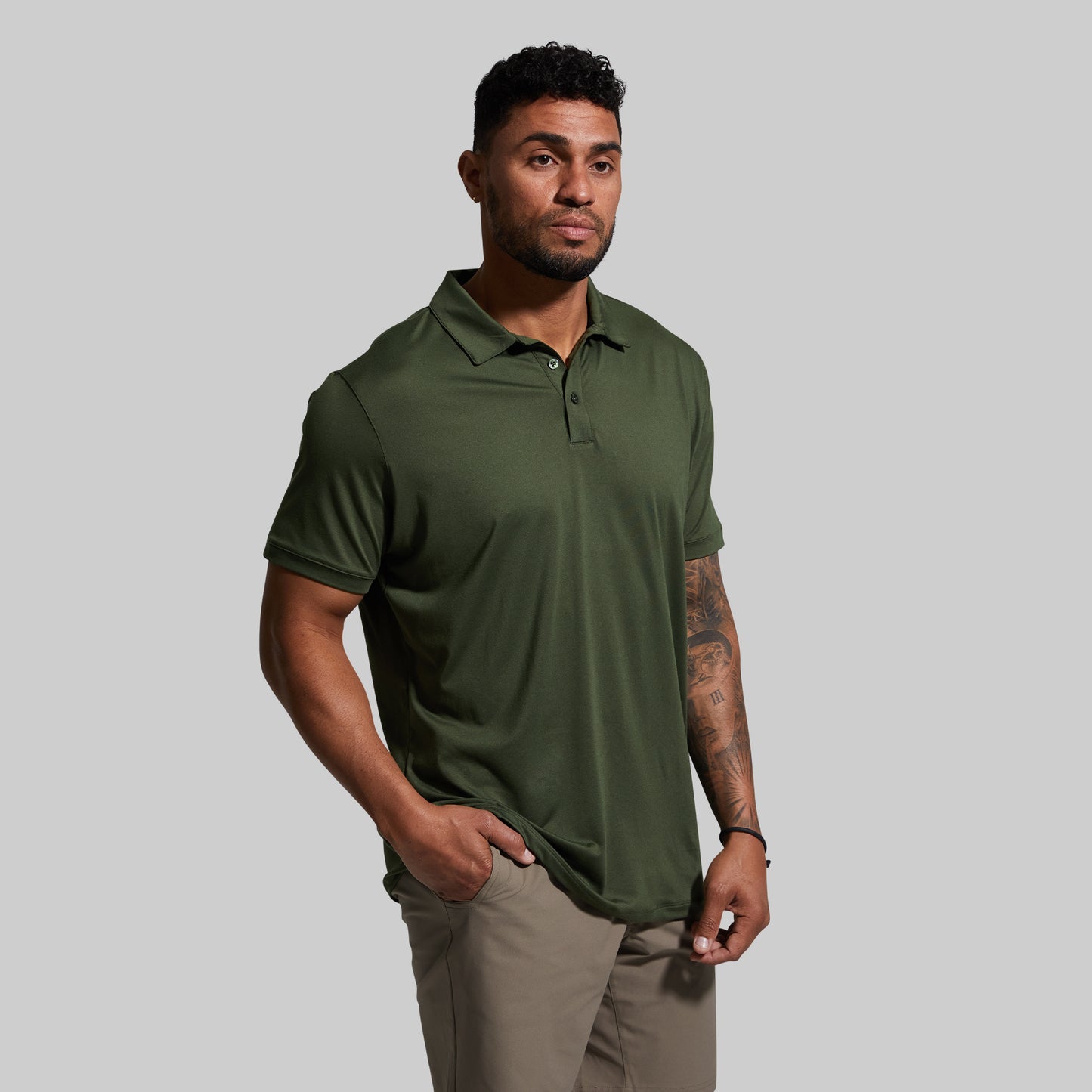 Man wearing a green polo shirt against a gray background