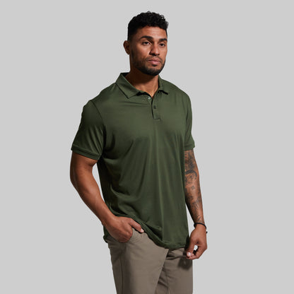 Man wearing a green polo shirt against a gray background