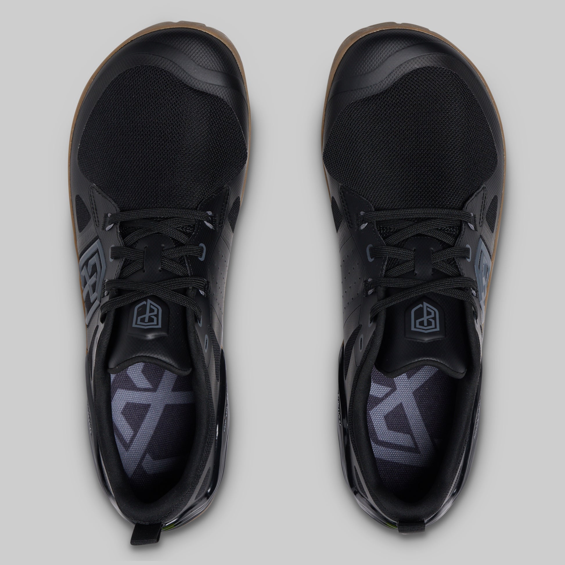 A pair of black low-top athletic shoes shown from a top-down view on a light gray background.