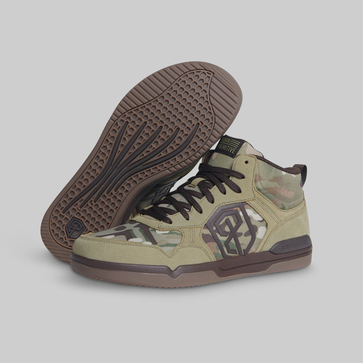 A pair of mid-top sneakers in a beige and green camouflage pattern, featuring dark brown soles and a dark brown side logo, shown against a solid gray background.