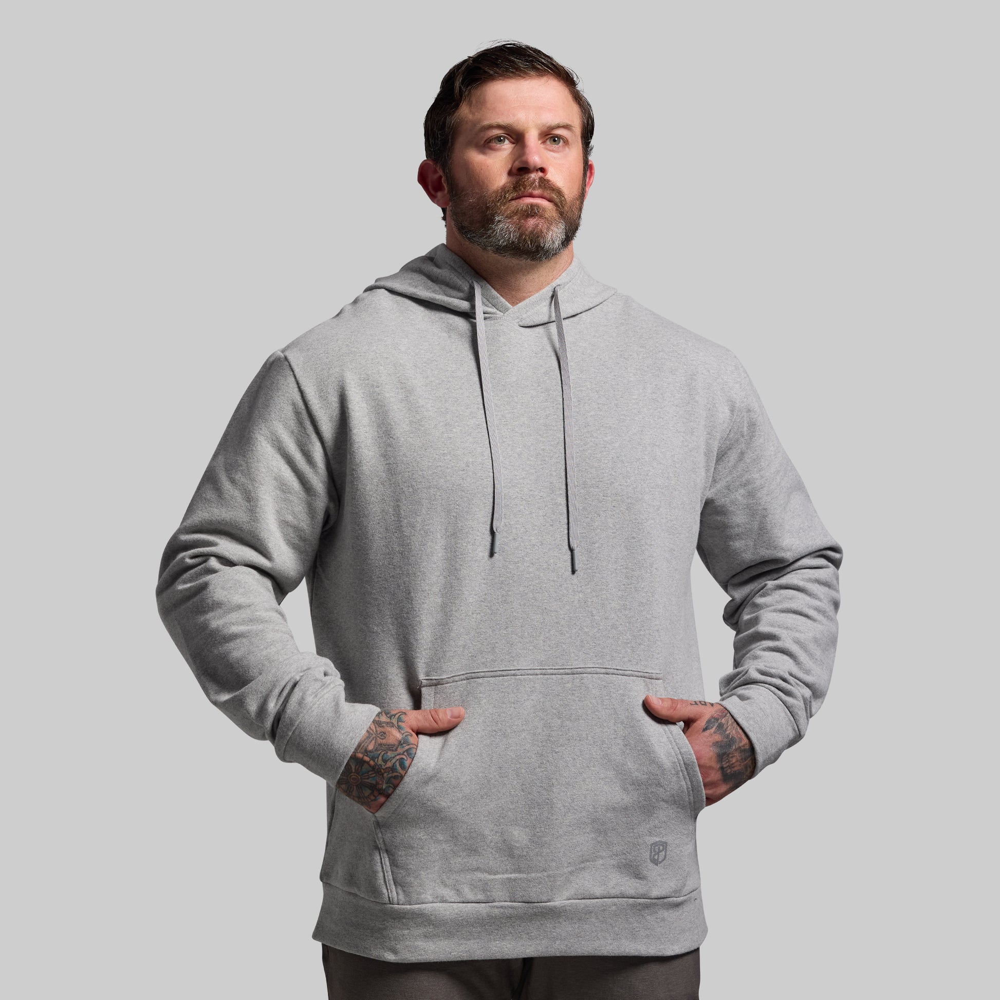 Man wearing a gray hoodie against a plain background