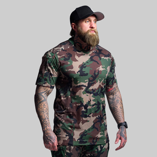Man wearing a camouflage t-shirt and cap on a gray background