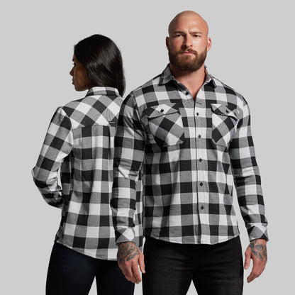 Two people wearing black and white checkered shirts against a gray background