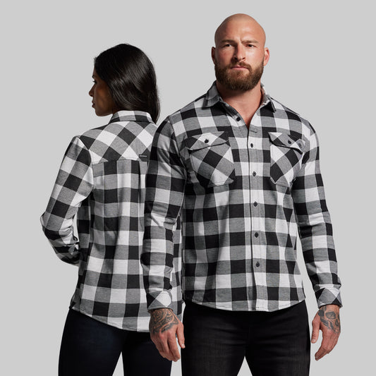 Two people wearing black and white checkered shirts against a gray background