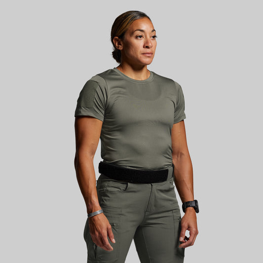 Person wearing a green tactical outfit on a gray background
