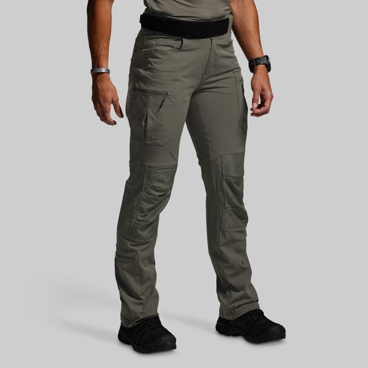 Person wearing green tactical pants on a light gray background