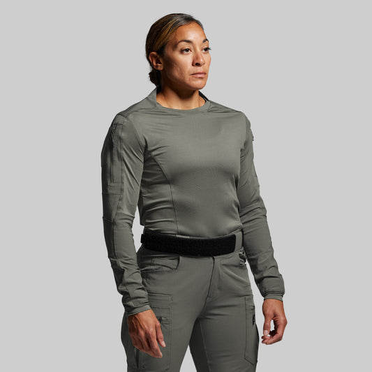 Person wearing a green tactical outfit on a plain background
