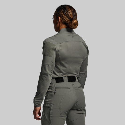Person wearing a green tactical outfit on a gray background