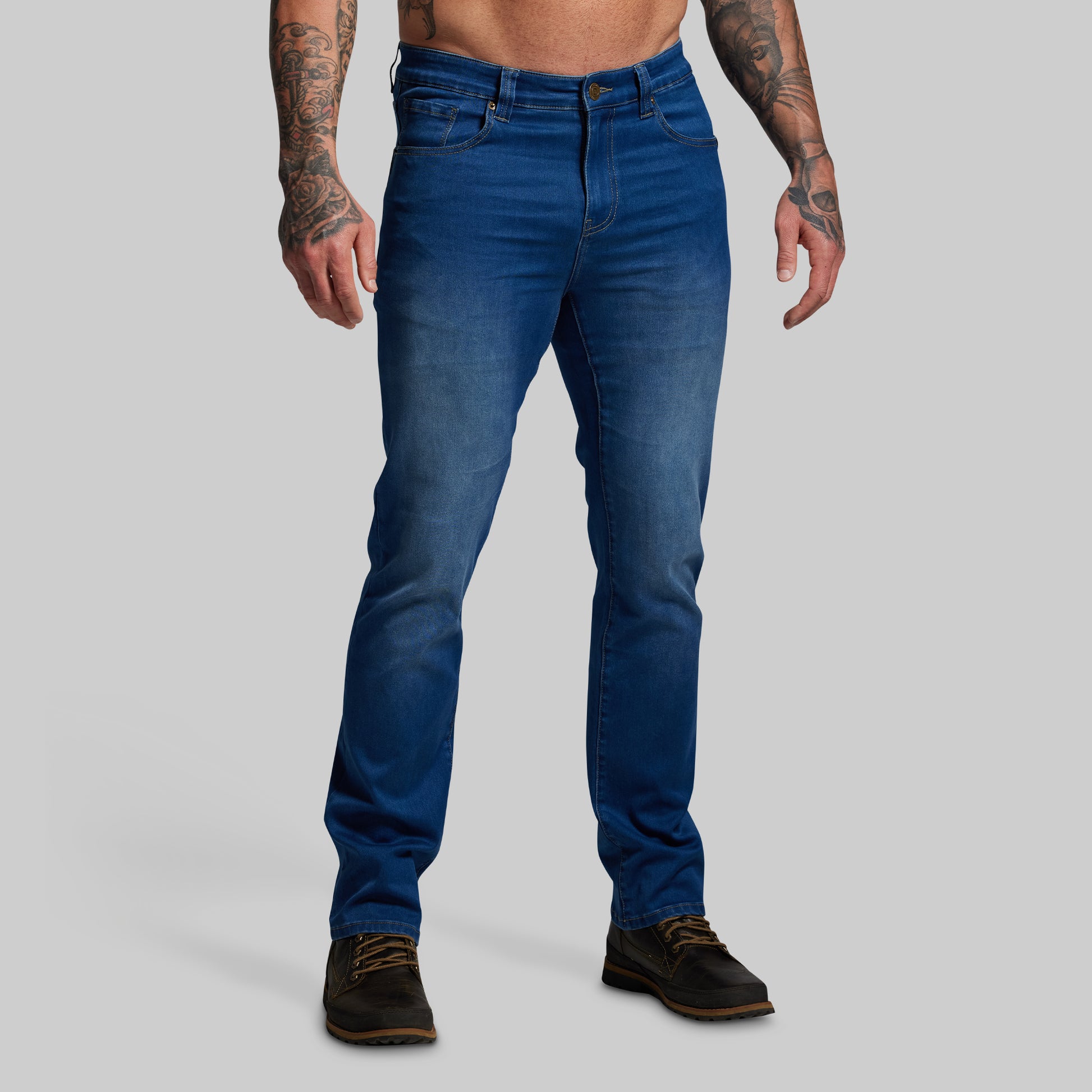 Person wearing blue jeans on a gray background