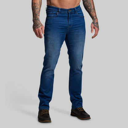 Person wearing blue jeans on a gray background