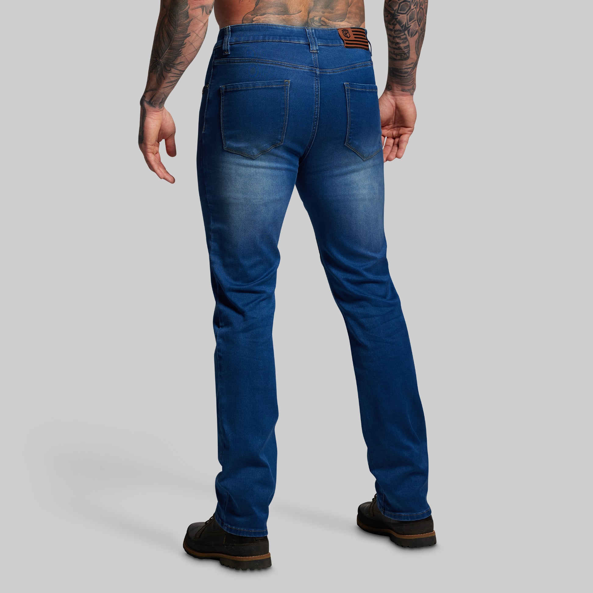 Person wearing blue jeans on a gray background