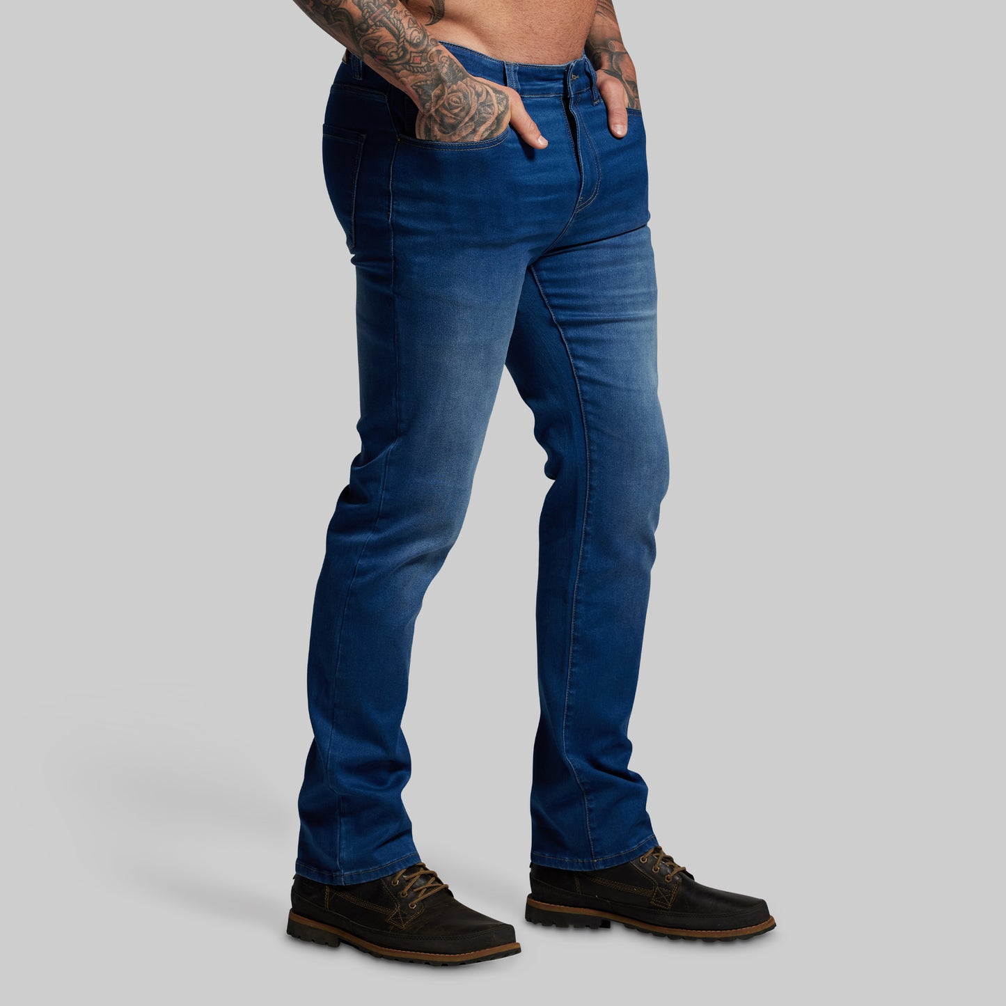 Person wearing blue jeans on a gray background
