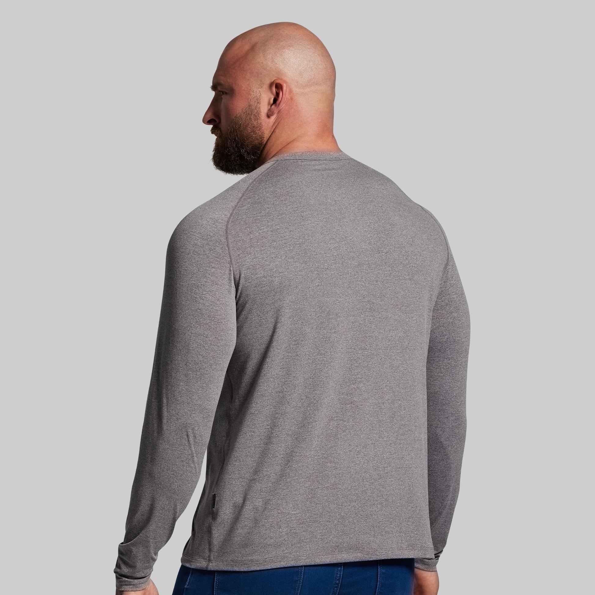 Man wearing a gray long-sleeve shirt against a plain background