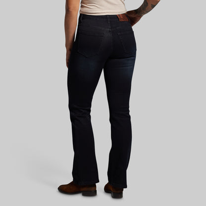 Person wearing black jeans on a plain background