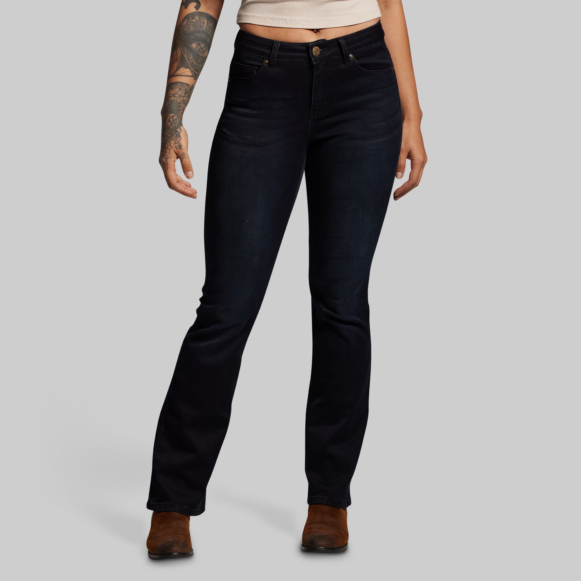Person wearing black jeans on a gray background