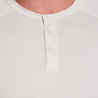 Close-up of a white shirt with button details on a light gray background