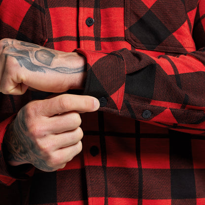 Red and black plaid shirt with a close-up of a hand adjusting the cuff.