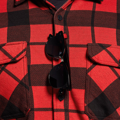Red and black plaid shirt with sunglasses on top