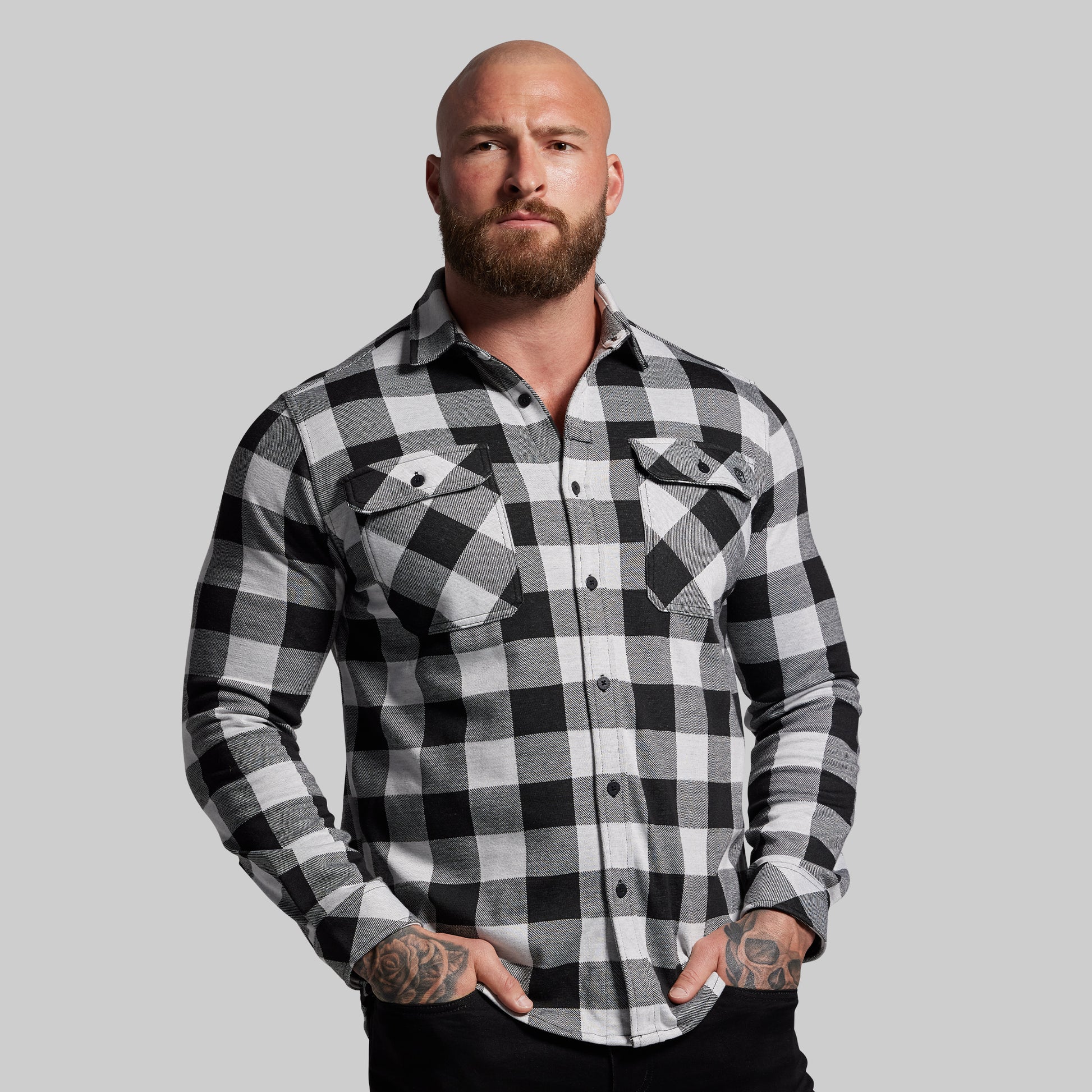 Man wearing a black and white checkered shirt against a gray background