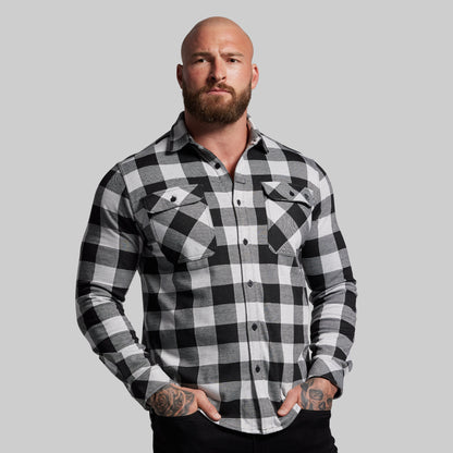 Man wearing a black and white checkered shirt against a gray background