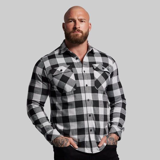 Man wearing a black and white checkered shirt against a gray background