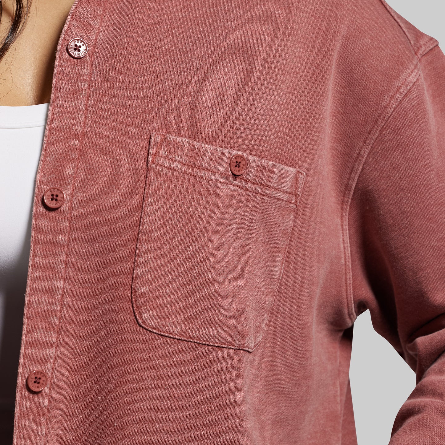 Close-up of a red shirt with a pocket on a plain background