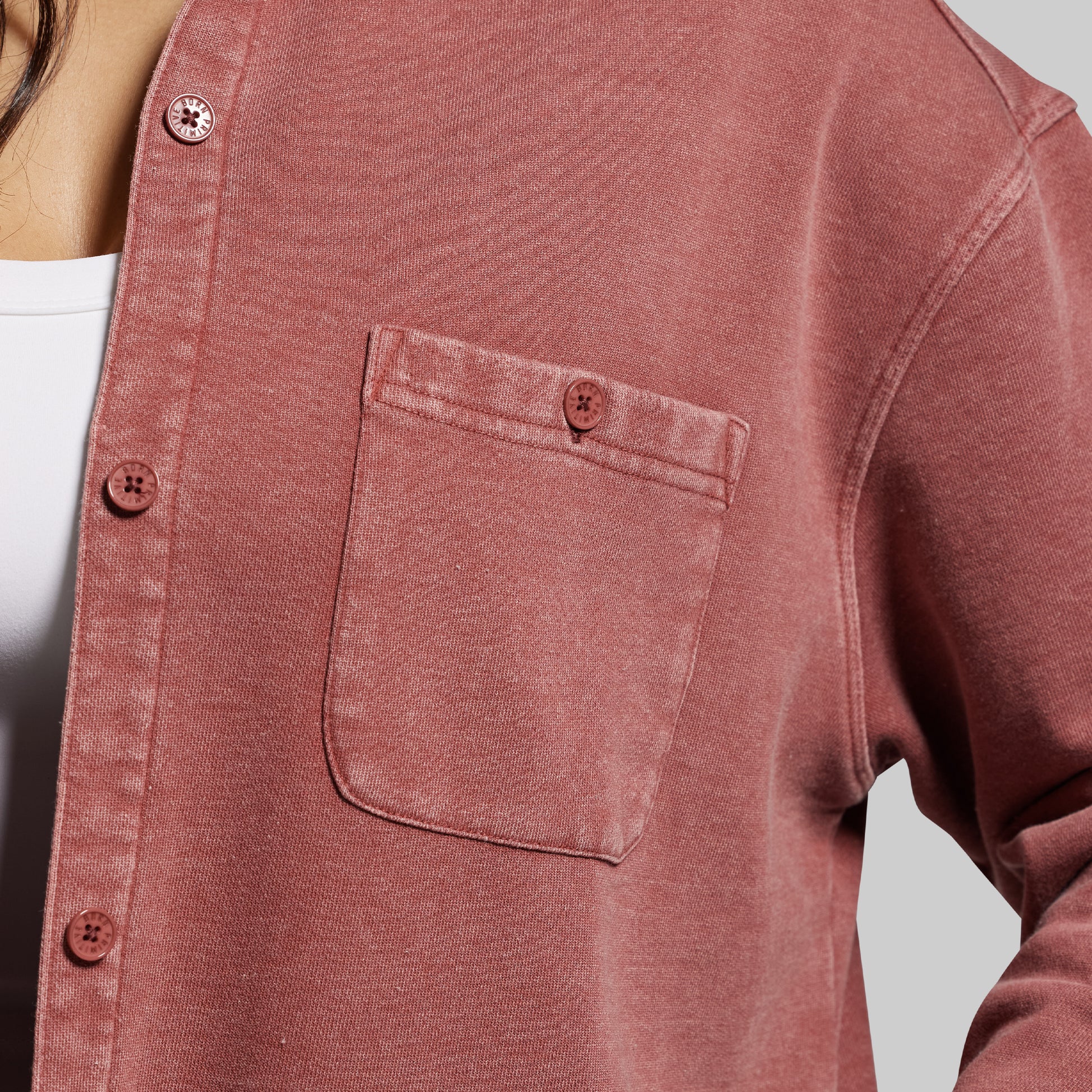 Close-up of a red shirt with a pocket on a plain background