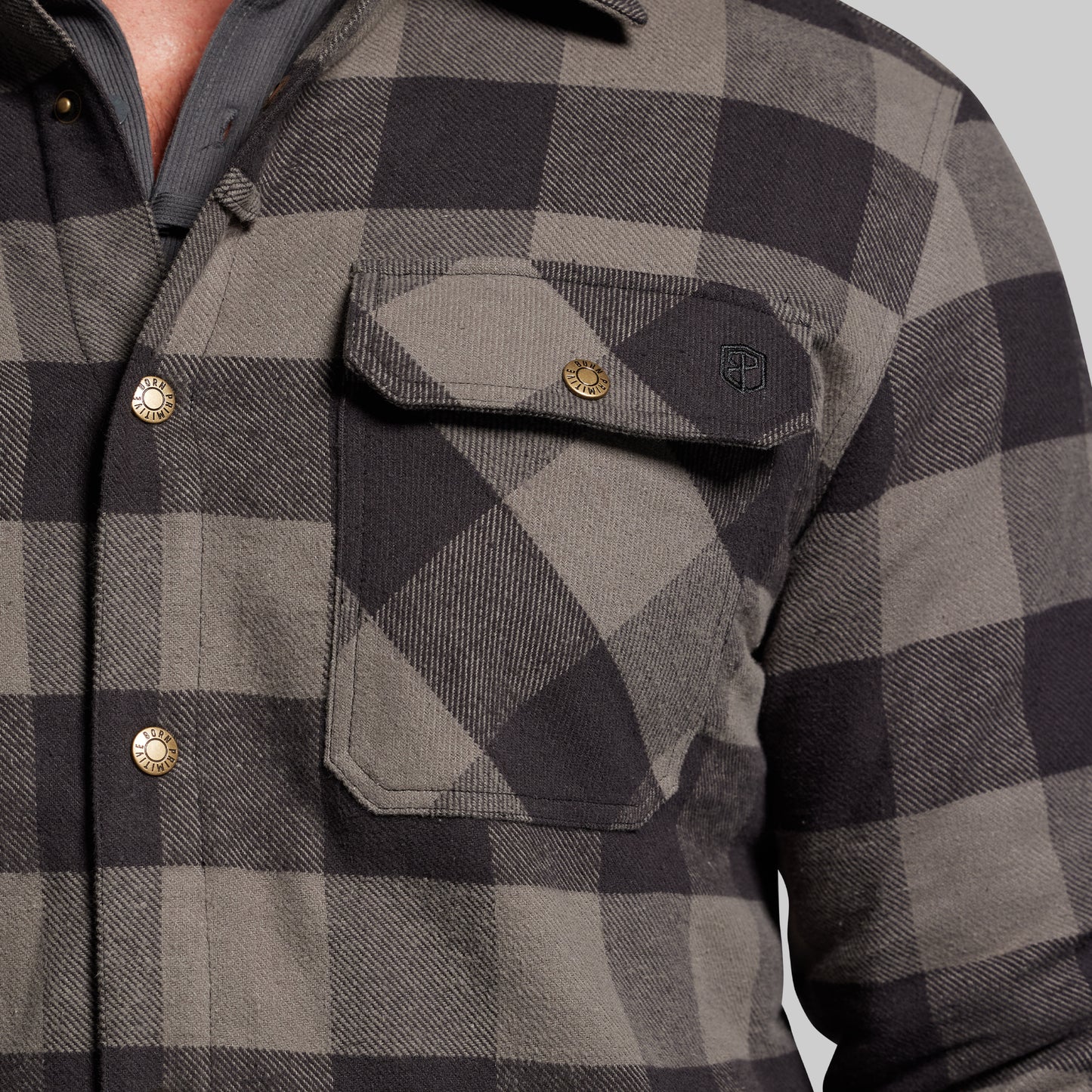 Close-up of a gray and black checkered jacket with button details.