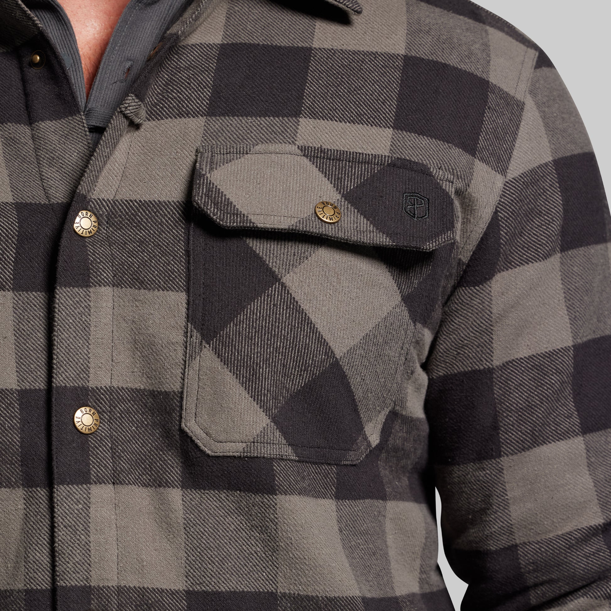 Close-up of a gray and black checkered jacket with button details.