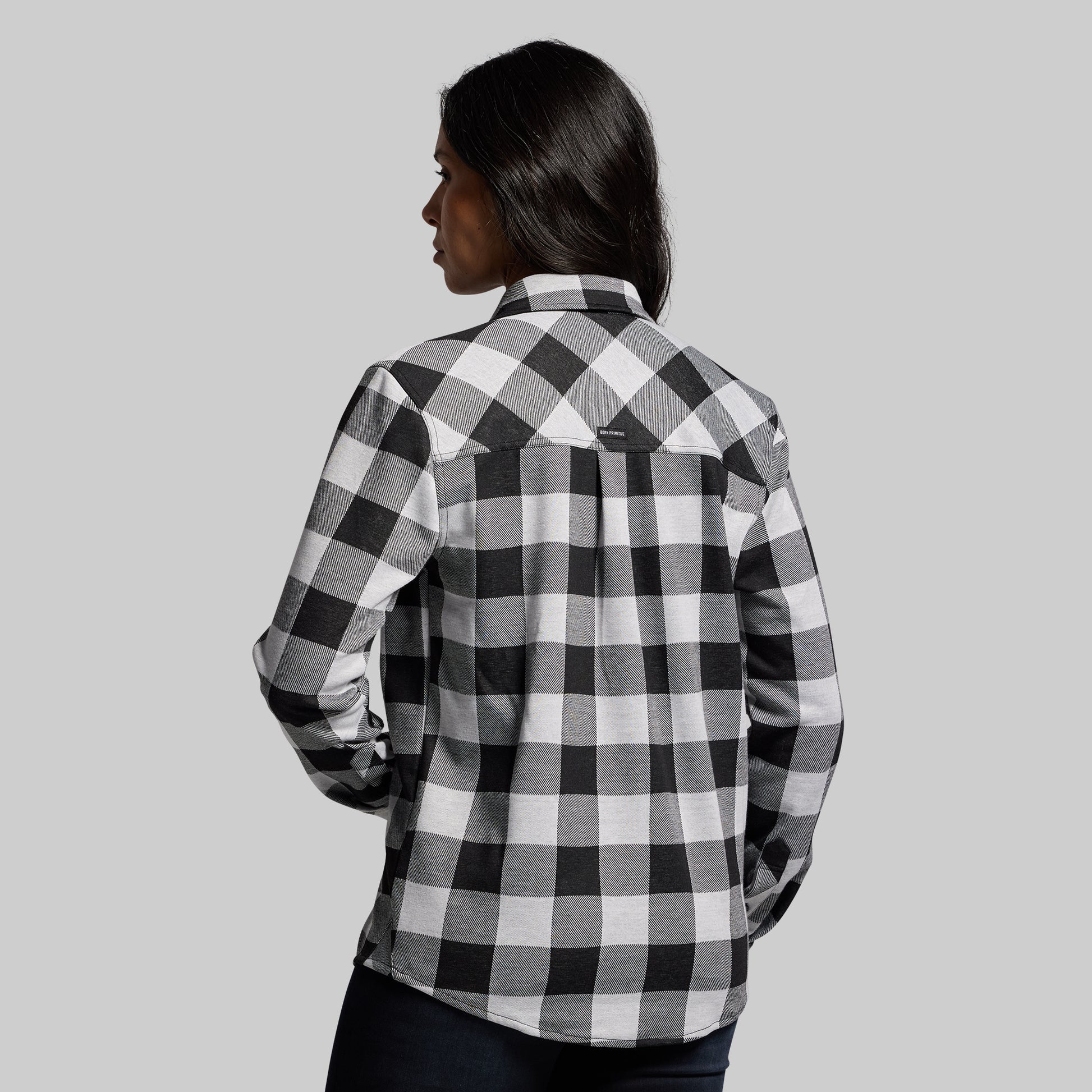 Person wearing a black and white checkered shirt against a gray background