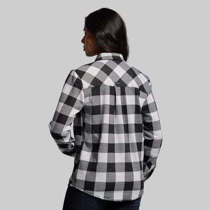 Person wearing a black and white checkered shirt against a gray background