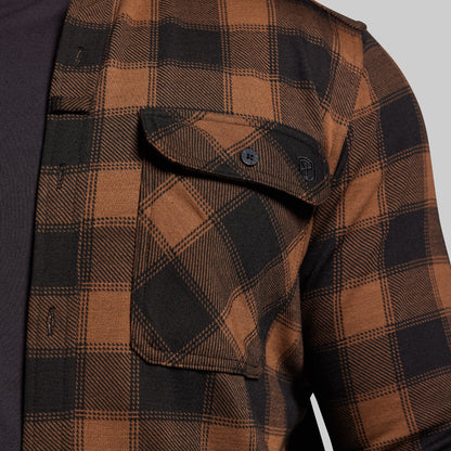 Brown and black plaid shirt with a buttoned pocket on a gray background