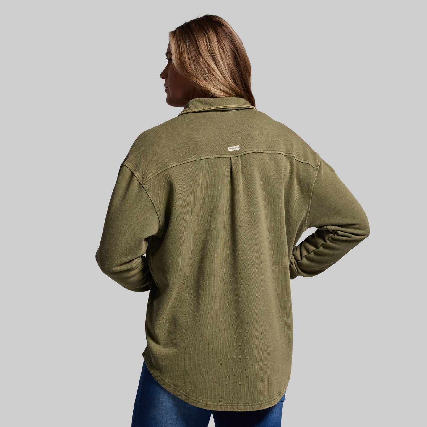 Person wearing a green shirt on a gray background