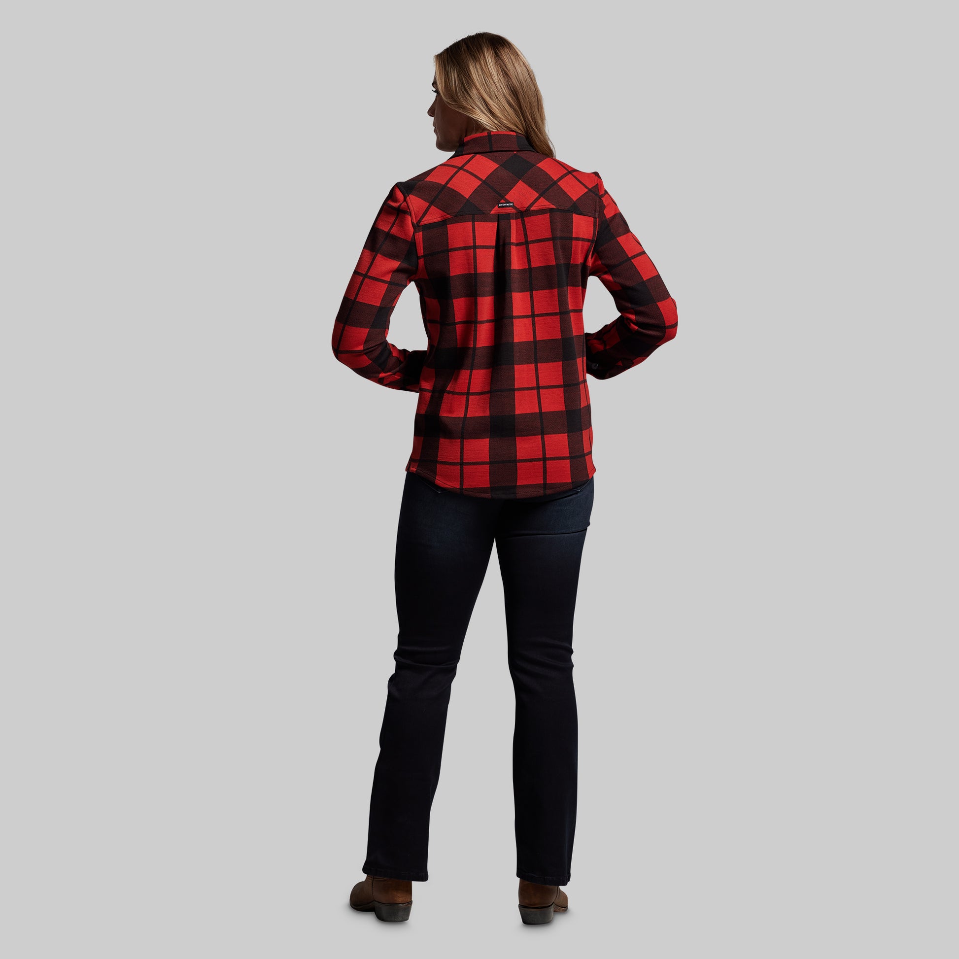 Person wearing a red and black plaid shirt on a gray background