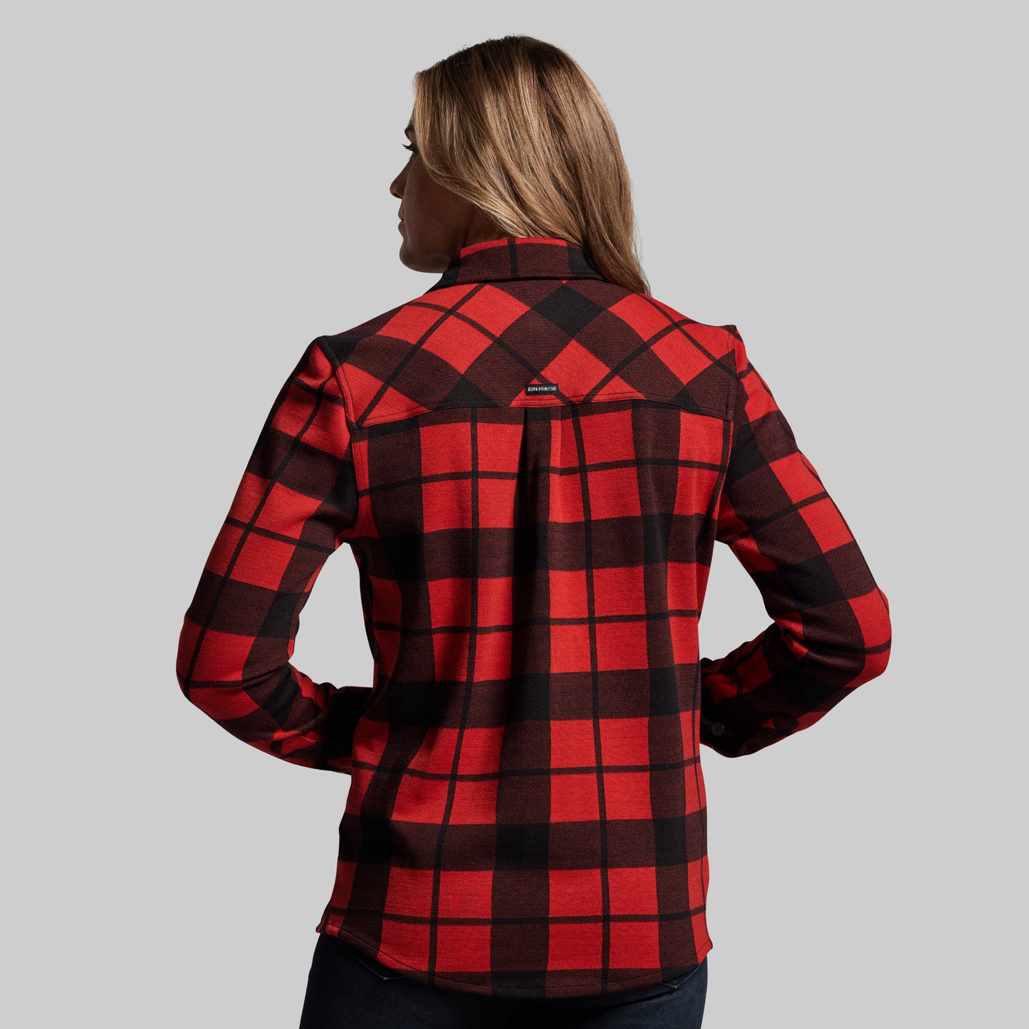 Red and black checkered shirt worn by a person on a gray background