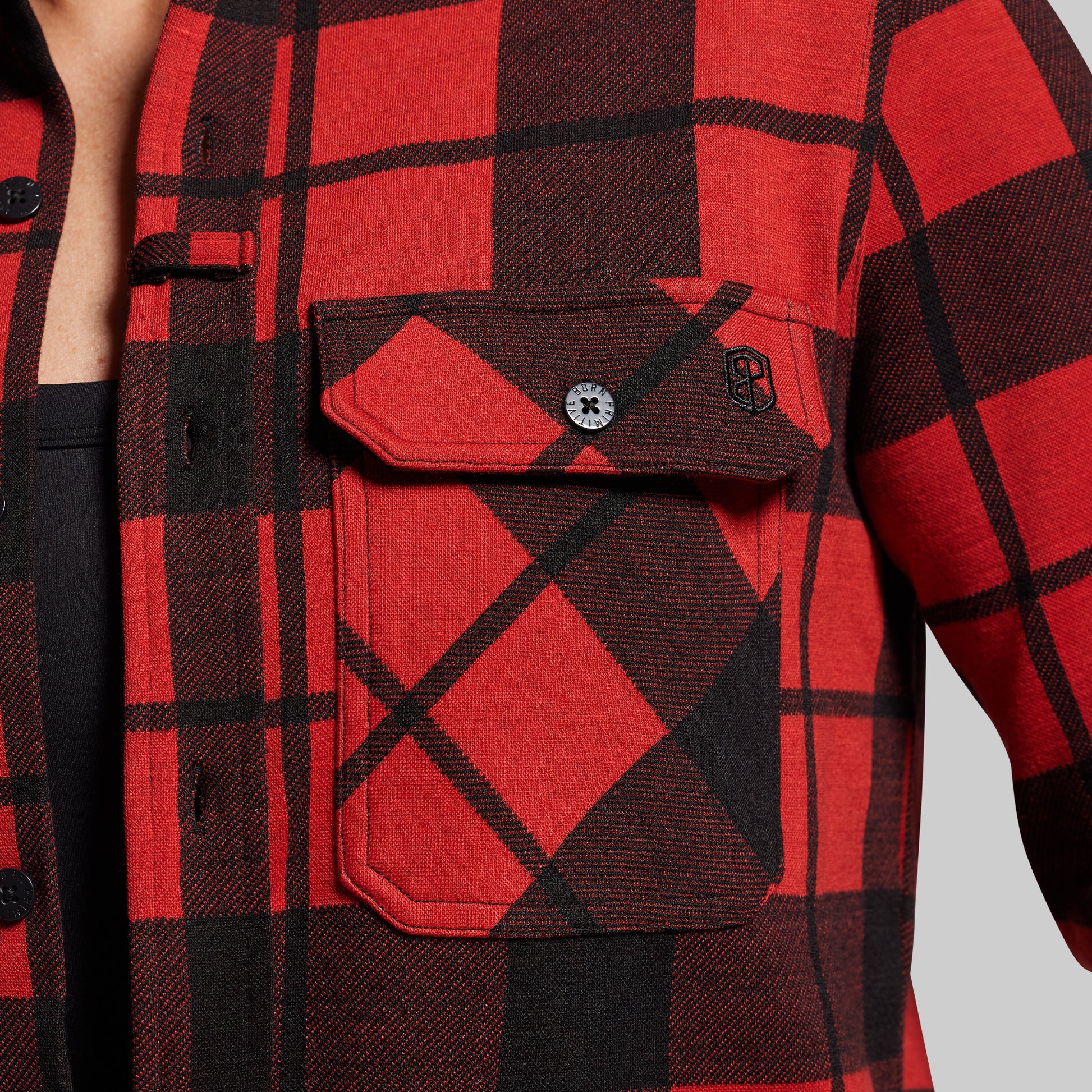 Red and black plaid shirt with a pocket on a gray background