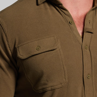 Close-up of a brown corduroy shirt with two front pockets.