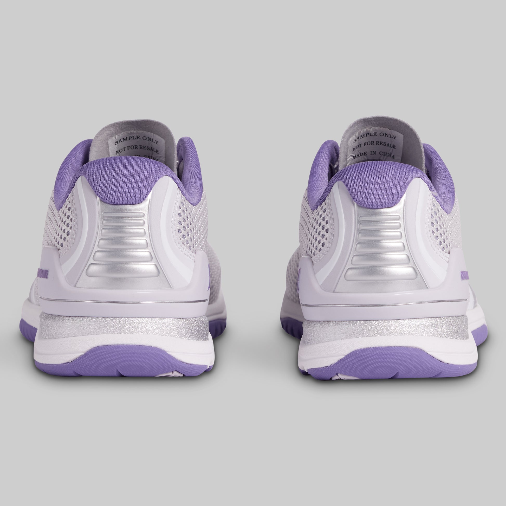 White and purple athletic shoes on a gray background