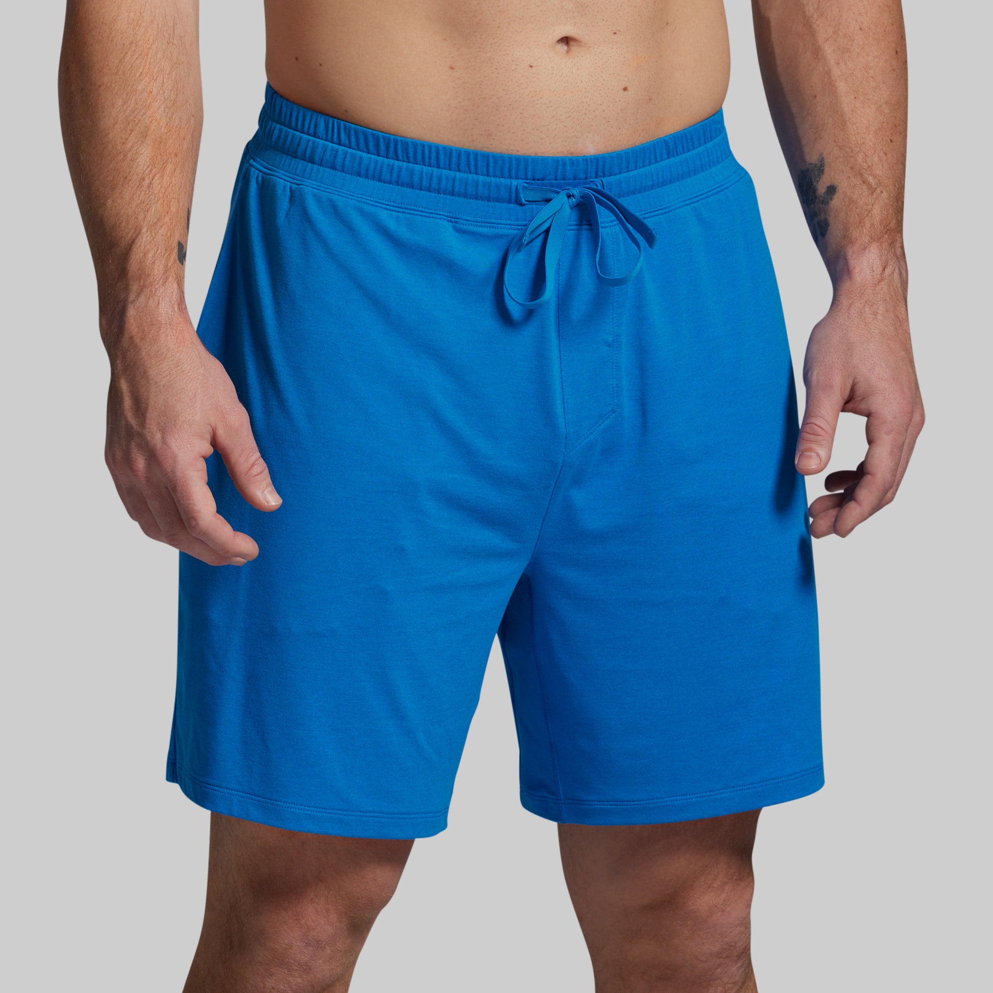 Blue shorts worn by a person on a gray background