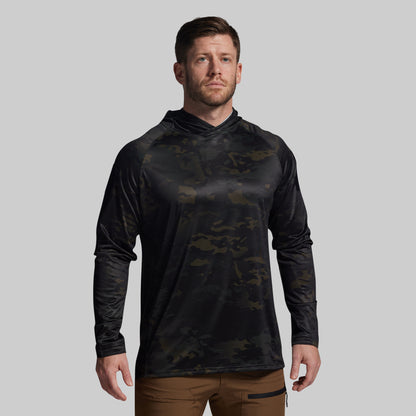 Man wearing a black camouflage long-sleeve shirt on a gray background