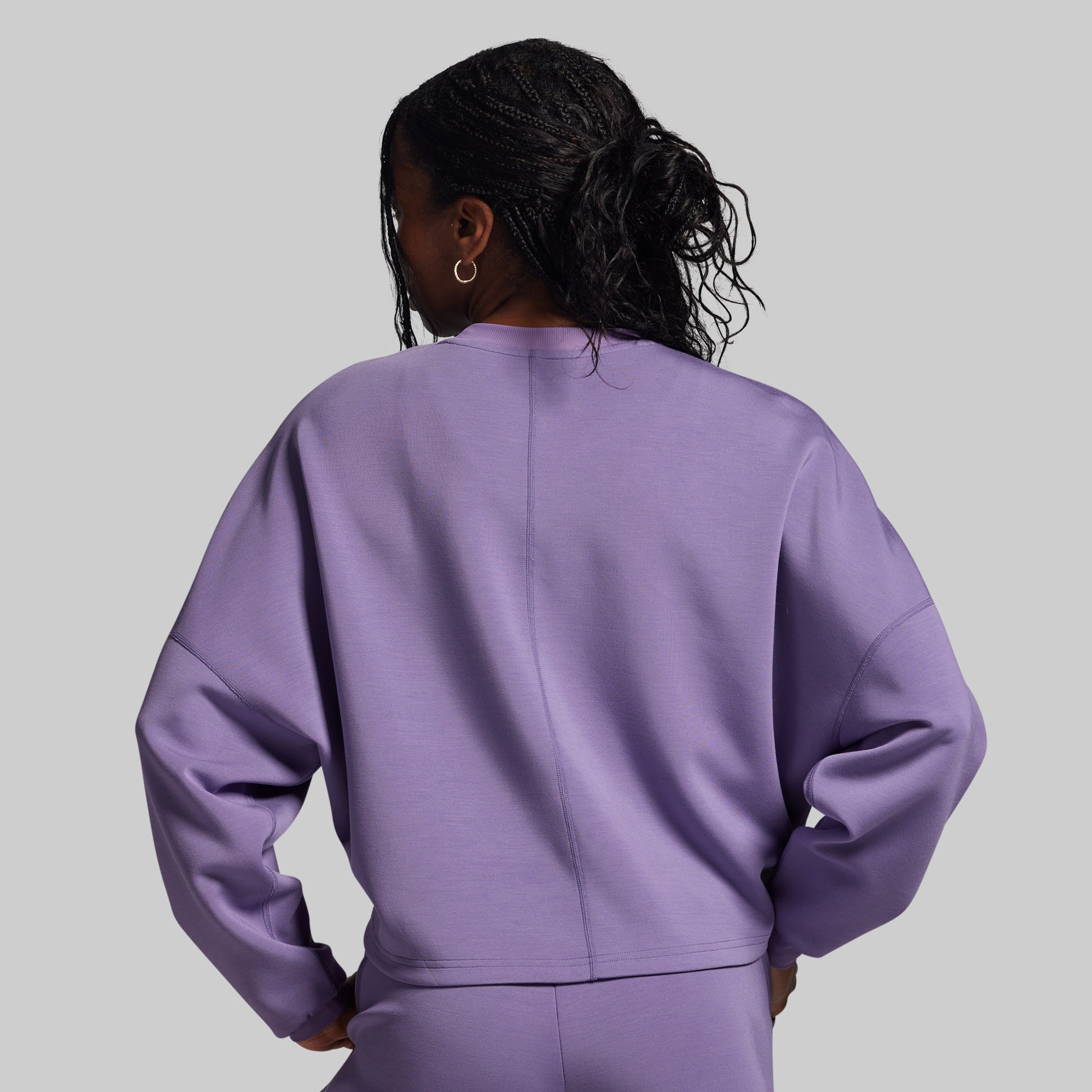 Person wearing a purple outfit against a gray background