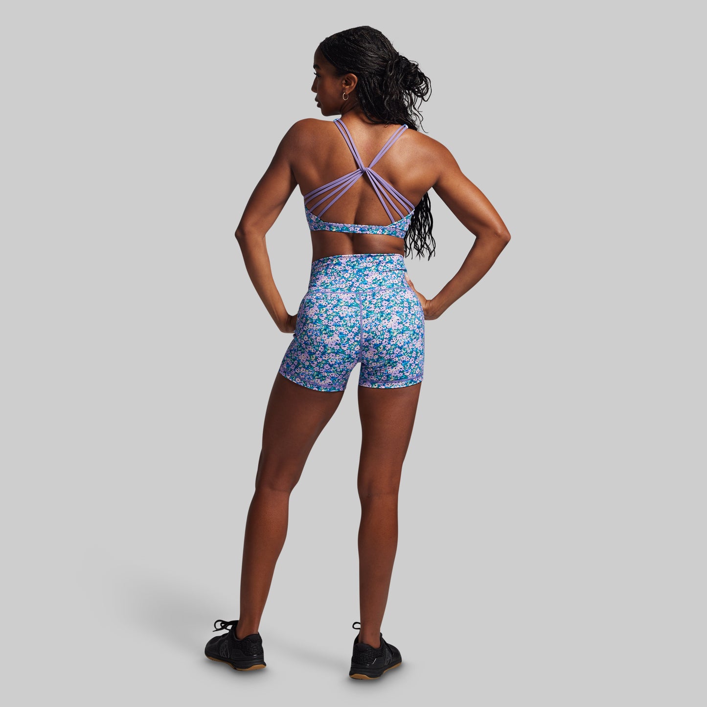 Woman wearing a floral sports outfit on a gray background