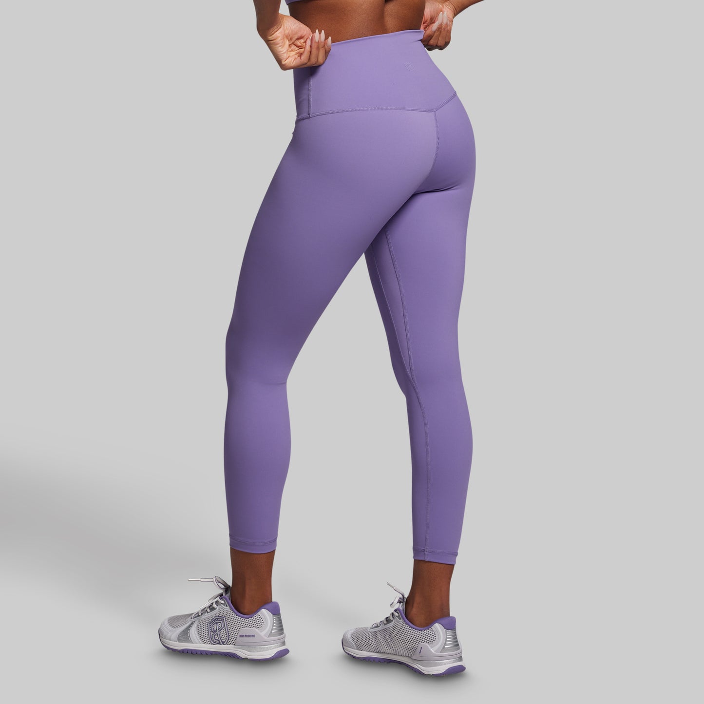 Person wearing purple leggings on a gray background